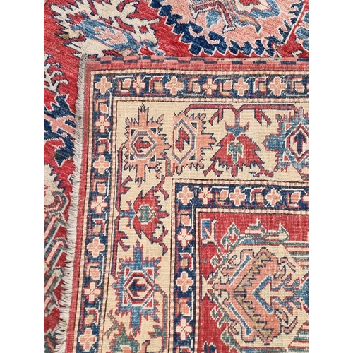 1103 - A Tribal design rug, having geometric and floral borders, 218 x 175cm.