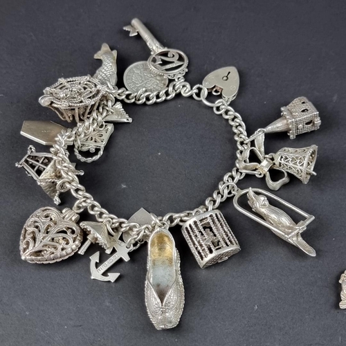 434 - Two similar bracelets, with padlock clasps and twenty attached charms and similar, some stamped silv... 