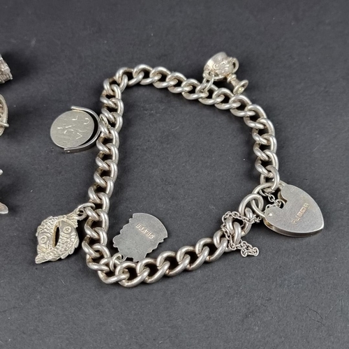 434 - Two similar bracelets, with padlock clasps and twenty attached charms and similar, some stamped silv... 