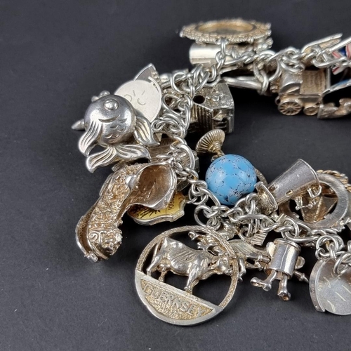 435 - A charm bracelet, with padlock clasp set with approximately 40 charms and similar, mostly stamped si... 