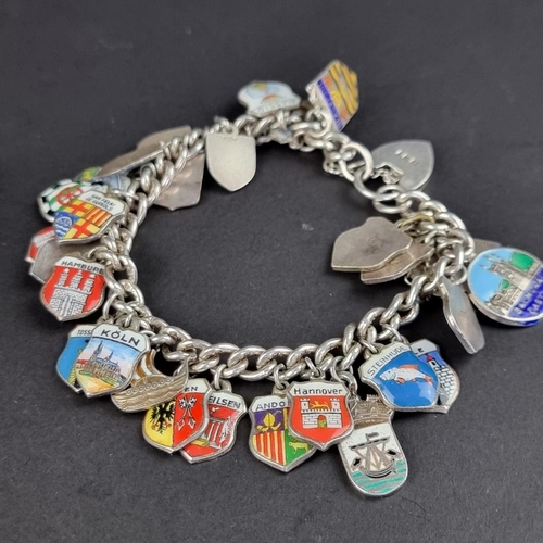 437 - Two similar bracelets, with approximately fifty seven attached charms and and enamel decorated crest... 