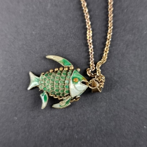 484 - A green enamel decorated fish pendant, the bale stamped 'Silver', on unmarked metal chain.... 