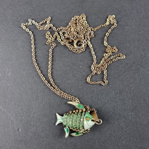 484 - A green enamel decorated fish pendant, the bale stamped 'Silver', on unmarked metal chain.... 