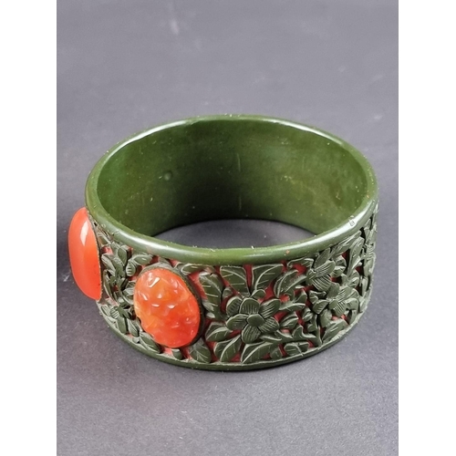 487 - A vintage Chinese green and red lacquer bangle, set with three carnelians, 75mm diameter, in origina... 