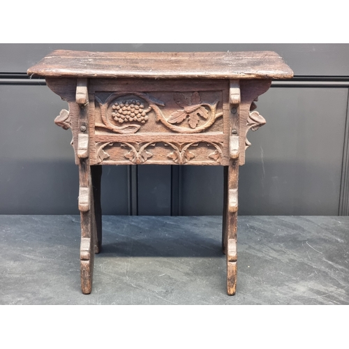 1007 - A 17th century carved oak boarded stool, the frieze carved with fruiting vines and tracery, 53cm wid... 