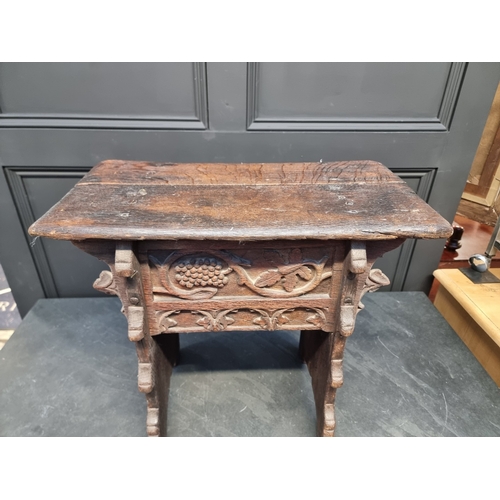 1007 - A 17th century carved oak boarded stool, the frieze carved with fruiting vines and tracery, 53cm wid... 