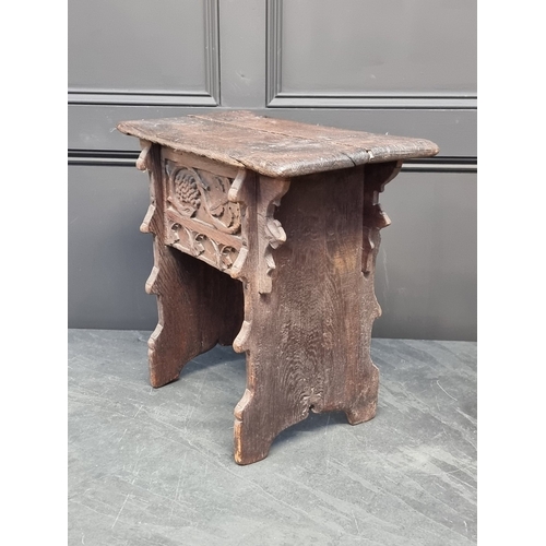 1007 - A 17th century carved oak boarded stool, the frieze carved with fruiting vines and tracery, 53cm wid... 