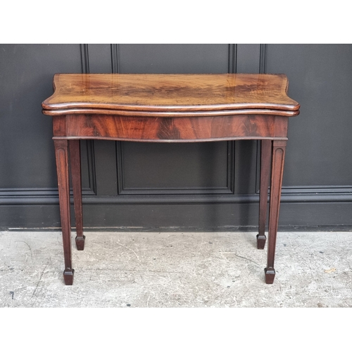 1051 - A George III figured mahogany and crossbanded serpentine concertina card table, 91.5cm wide.... 