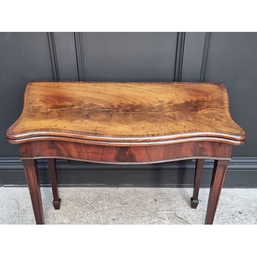 1051 - A George III figured mahogany and crossbanded serpentine concertina card table, 91.5cm wide.... 