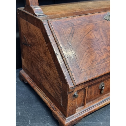 1055 - A George I walnut and feather banded mirror mounted table bureau, with fitted apron drawer, 93cm hig... 