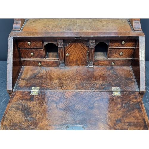 1055 - A George I walnut and feather banded mirror mounted table bureau, with fitted apron drawer, 93cm hig... 