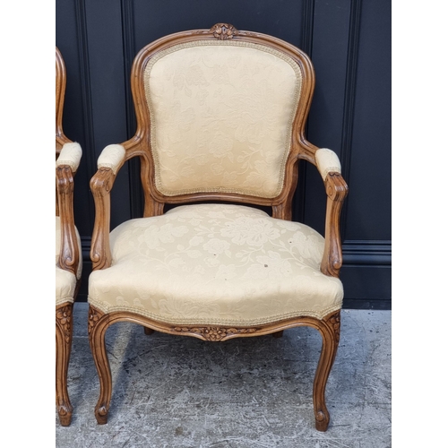 1061 - A pair of Louis XV style carved walnut fauteuils.