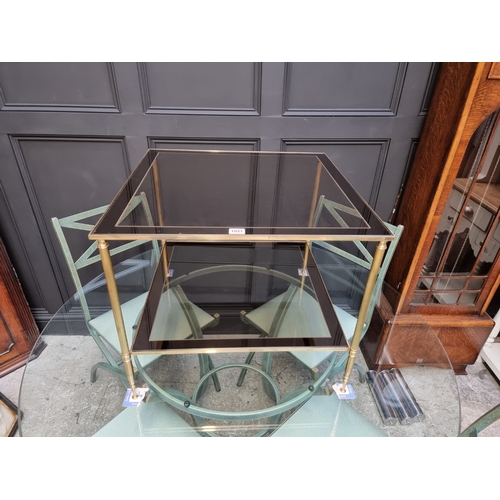 1021 - A brass and glass two-tier occasional table, 60.5cm wide.