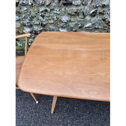 1050A - An Ercol dining suite, comprising a 'Windsor' table, with blue sticker, 153cm long; and a set of fou... 