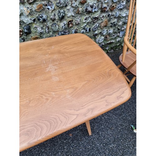 1050A - An Ercol dining suite, comprising a 'Windsor' table, with blue sticker, 153cm long; and a set of fou... 