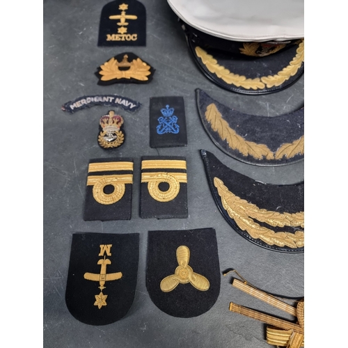 27 - A group of Royal Navy insignia and hat tallies, including royal yacht, HMS Agincourt and HM Submarin... 