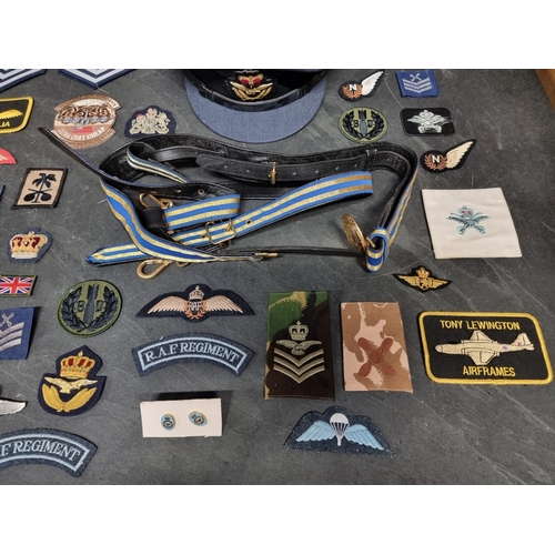 28 - A collection of RAF items, comprising: insignia, patches, wings, an officers peaked cap, and a sword... 