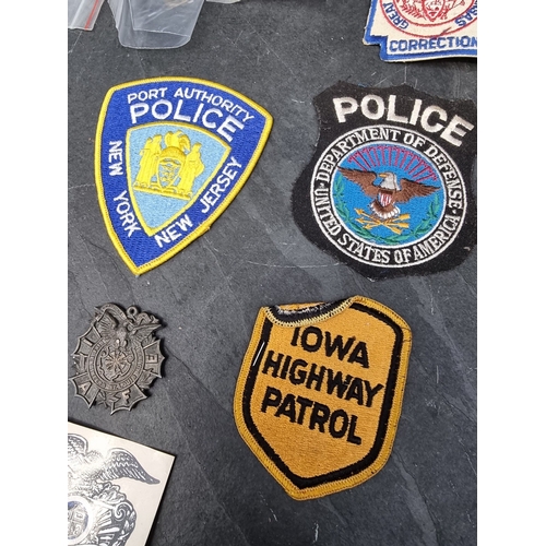 30 - A large quantity of US Police and other metal and fabric badges.