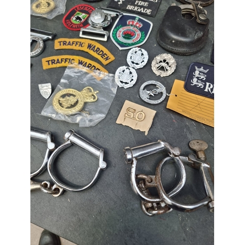 31 - A large collection of British and Colonial Police items; to include cap badges; handcuffs; and belt ... 