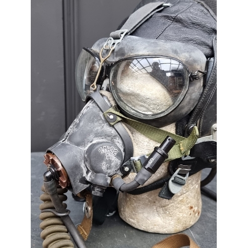 50 - A 1982 Soviet Mig pilot's leather flying helmet, size 58cm; together with goggles; and an oxygen mas... 