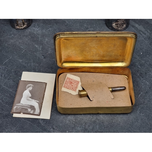 55 - A WWI Christmas 1914 brass tin, containing a bullet pencil, a monochrome photograph and a Christmas ... 