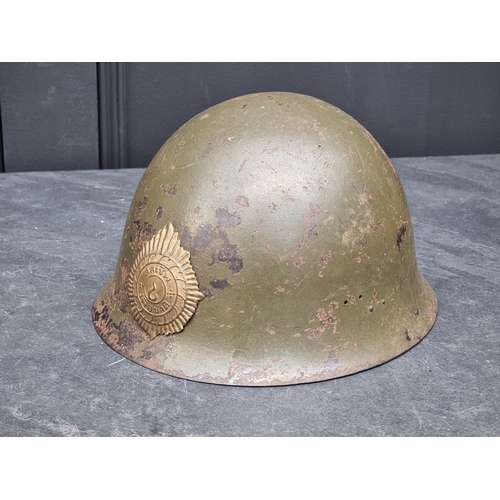 61 - A Korean War Thai infantry steel helmet, with lining, chinstrap and badge, purposed from a WWII Japa... 