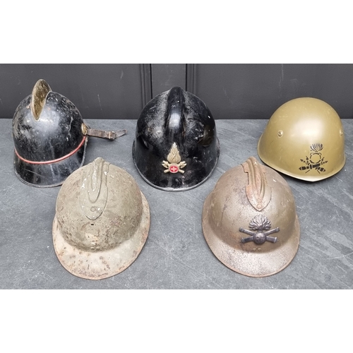 67 - Five various helmets, to include two WWI era French steel examples.