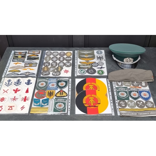 71 - A group of DDR Cold War East German Border Guard items, comprising: a peaked cap, an army forage cap... 