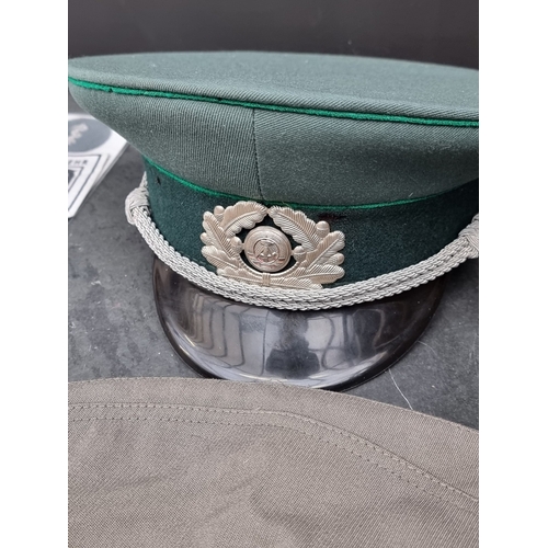 71 - A group of DDR Cold War East German Border Guard items, comprising: a peaked cap, an army forage cap... 