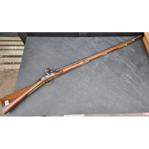 76 - An 18th century flintlock Brown Bess musket, with 101cm barrel and walnut stock, the lock plate stam... 