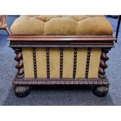 1058 - A Victorian carved rosewood and button upholstered ottoman, on gilt and ebonized ball & claw fee... 