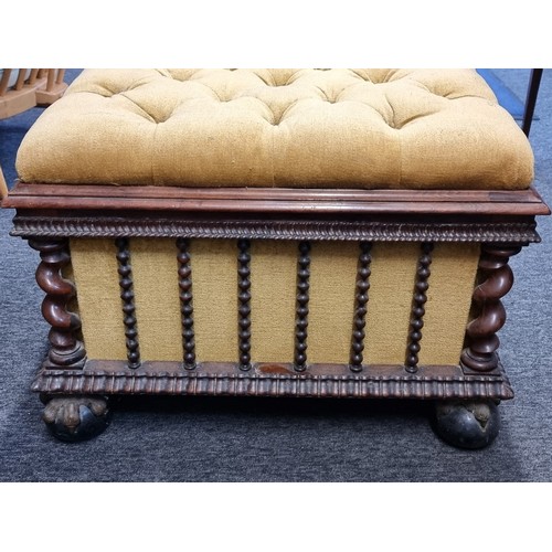 1058 - A Victorian carved rosewood and button upholstered ottoman, on gilt and ebonized ball & claw fee... 