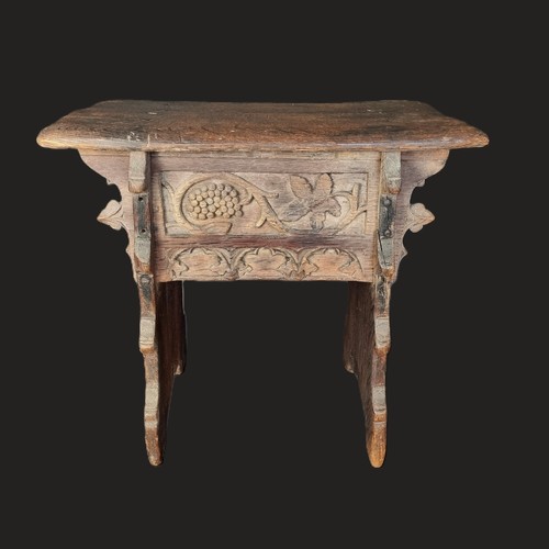 1007 - A 17th century carved oak boarded stool, the frieze carved with fruiting vines and tracery, 53cm wid... 