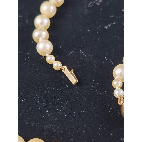 158 - A cultured pearl necklace, having clasp stamped '750', 80cm long; together with another synthetic pe... 