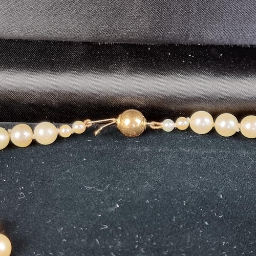 158 - A cultured pearl necklace, having clasp stamped '750', 80cm long; together with another synthetic pe... 