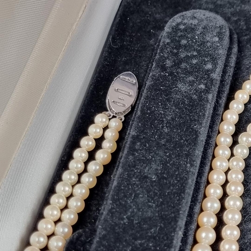 158 - A cultured pearl necklace, having clasp stamped '750', 80cm long; together with another synthetic pe... 