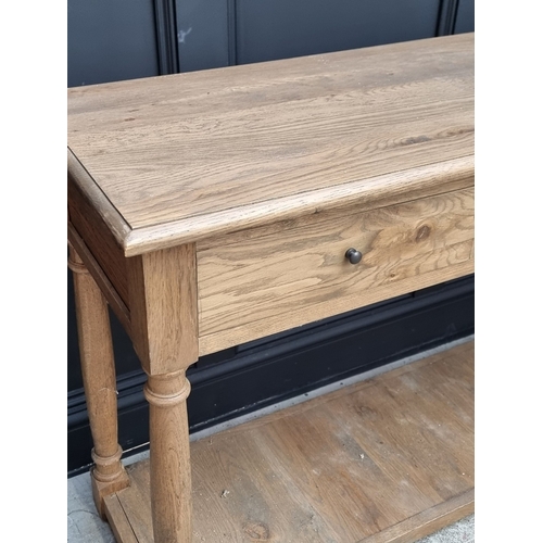 1004 - A contemporary oak three drawer side table, with platform undertier, 150cm wide.