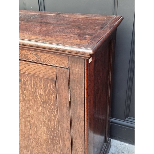 1047 - A 19th century oak panelled side cabinet, 154cm wide.