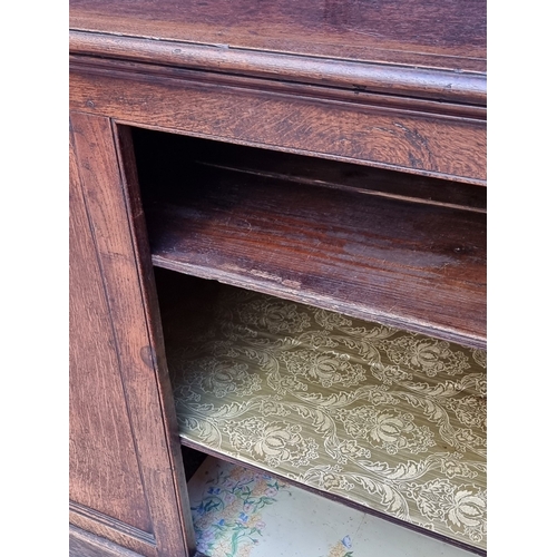 1047 - A 19th century oak panelled side cabinet, 154cm wide.