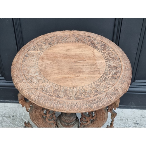 1050 - An Eastern carved hardwood circular tripod table, 45cm diameter.