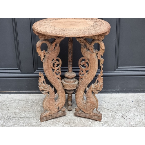 1050 - An Eastern carved hardwood circular tripod table, 45cm diameter.