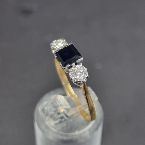 176 - A yellow metal sapphire and diamond three stone ring, stamped '18', set with a square sapphire and t... 