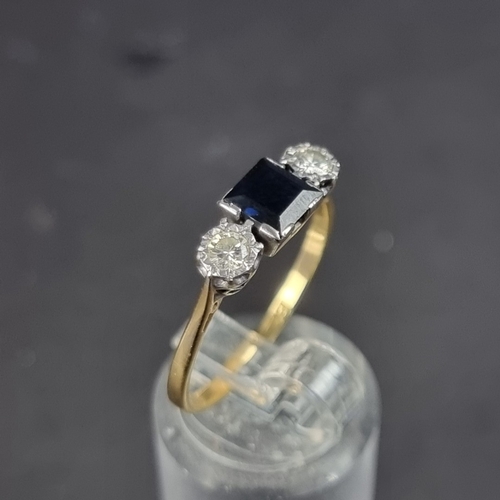 176 - A yellow metal sapphire and diamond three stone ring, stamped '18', set with a square sapphire and t... 