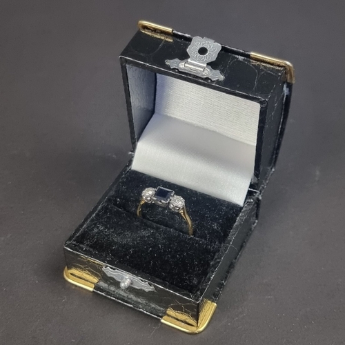 176 - A yellow metal sapphire and diamond three stone ring, stamped '18', set with a square sapphire and t... 