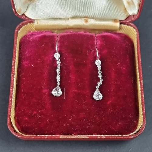 179 - A pair of diamond set pendant earrings, each having four collet set diamonds with a pear shaped diam... 