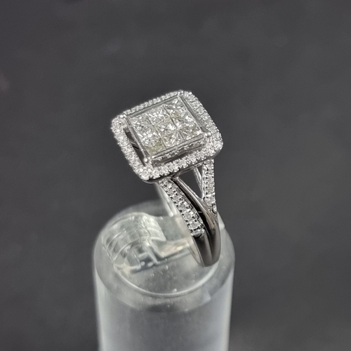 180 - A 9ct white gold diamond ring, pave set to centre with nine square cut diamonds surrounded with a bo... 