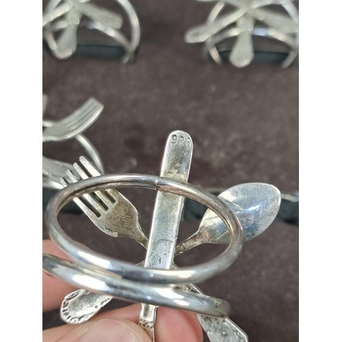 53 - A cased set of six white metal novelty knife, fork and spoon napkin rings, stamped 925.... 