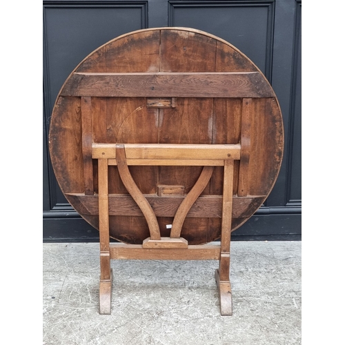 1012 - An 18th century French chestnut circular tilt-top vendage table, 96.5cm diameter.