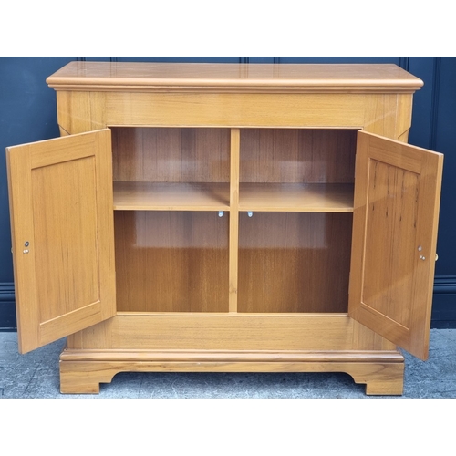 1016 - A teak and brass mounted side cabinet, 115cm wide.