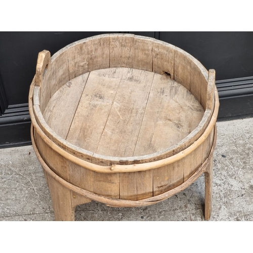 1020 - An antique Scandinavian staved pine twin handled tripod washing vessel, 59cm diameter.... 